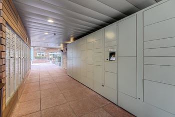A long hallway with a brown tile floor and white walls.